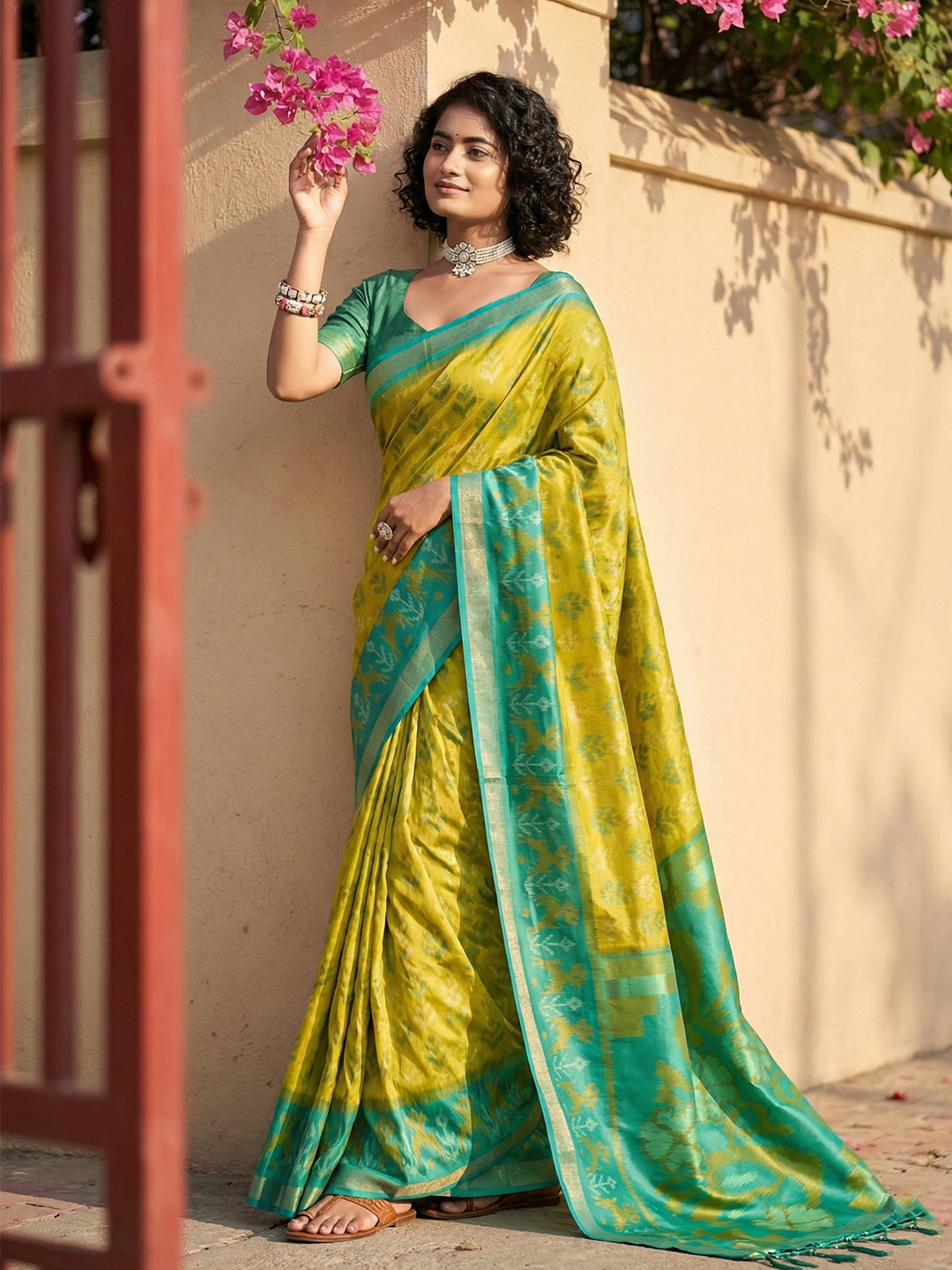 Lime yellow Patola inspired woven saree with teal contrast border and tassel pallu for festive wear