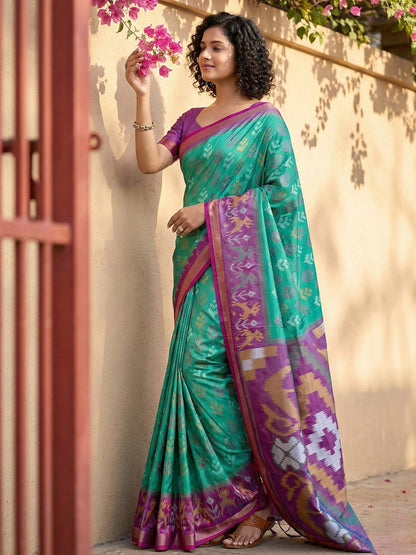 Sea green Patola inspired woven saree with purple contrast border and tassel pallu for festive wear
