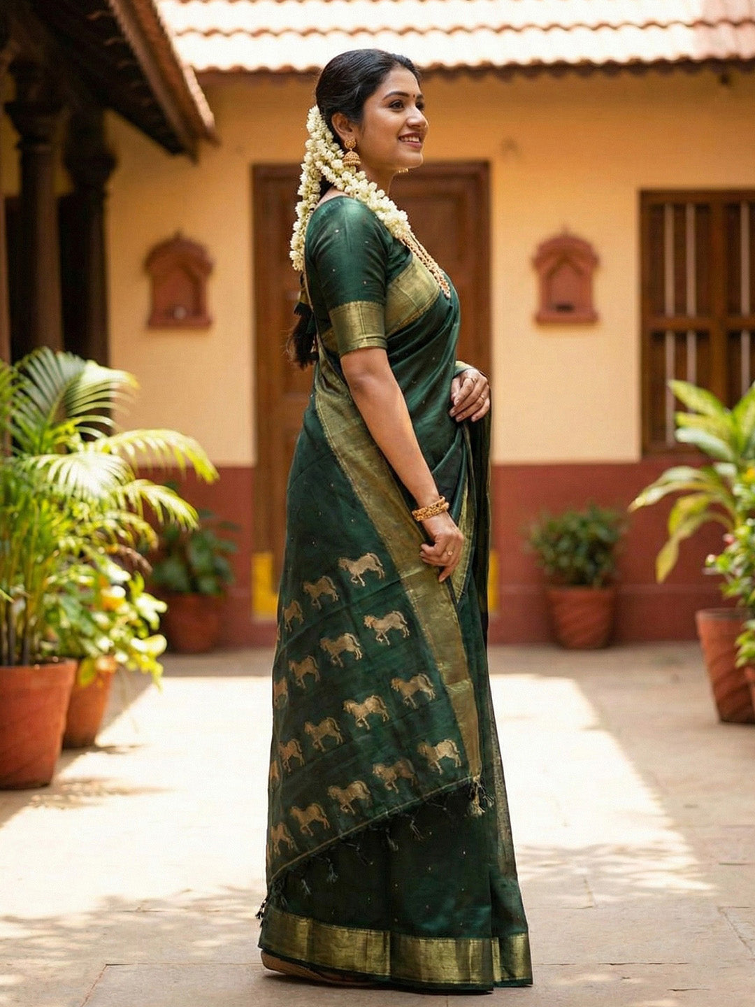 Dark green silk saree with wide gold zari border and woven horse motif
